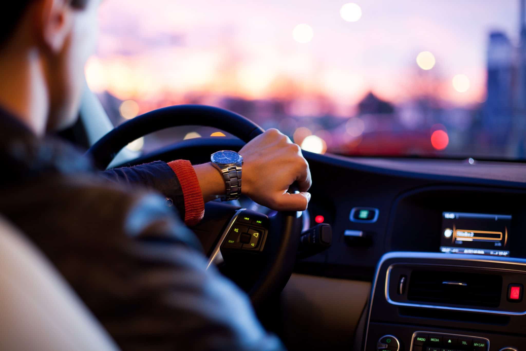 Inside view of a man driving with a watch on his wrist for Auto Insurance.
