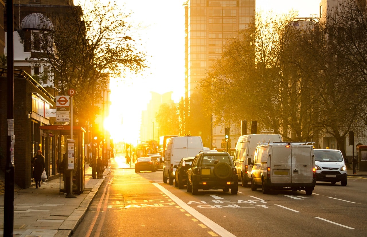 Business vehicles driving on street during sunset for Business Auto Insurance.