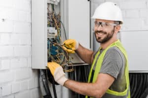 electrical contractor works on a fuse box