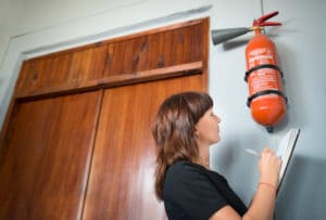 Young woman examines fire extinguisher