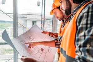 builders looking at blueprint on construction site