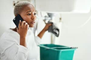Person calling insurance to ask a question whether homeowners insurance covers plumbing