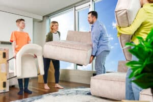 A family moving a new couch into their living room