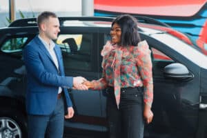 Salesman shaking hands with a buyer of a car