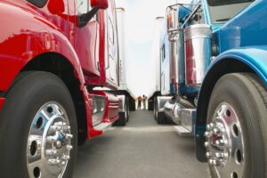 two people talking between two commercial trucks