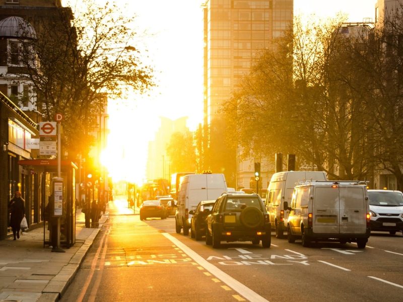 Business vehicles driving on street during sunset for Business Auto Insurance.