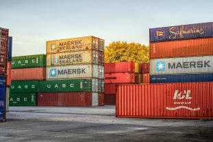 Inland Marine Insurance Multiple stacked cargo bins sitting outside for Inland Marine Insurance.